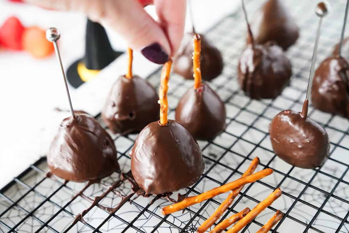 Adding pretzel sticks to chocolate covered strawberries